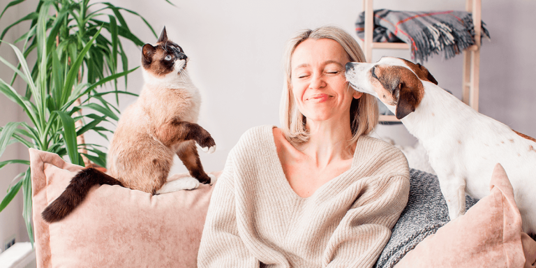 Mulher no sofá com seus animais de estimação, um cachorro e um gato.